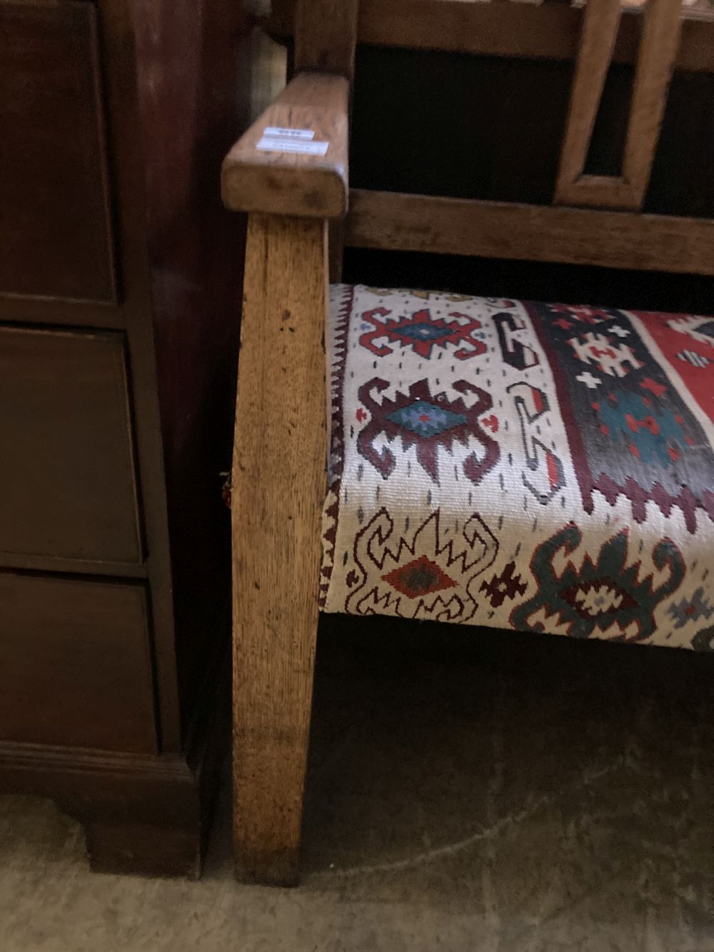 A 19th century Continental oak bench settle, with kelim upholstered seat, width 200cm depth 48cm height 104cm